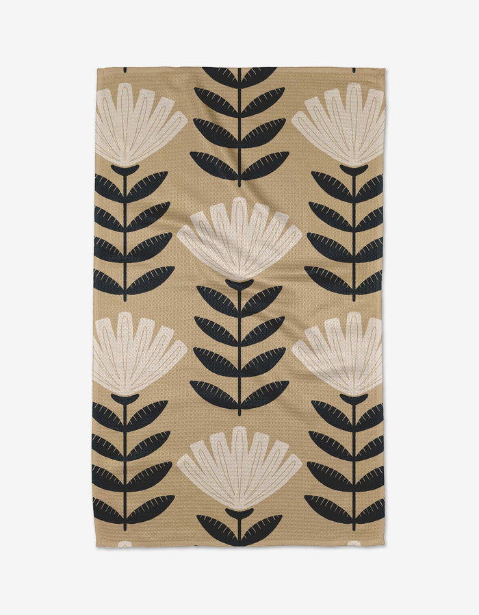 Floral patterned towel with black and white flowers on a beige background
