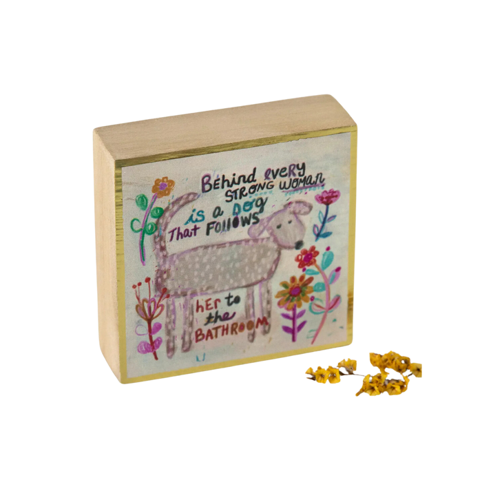 Decorative block depicting a dog with saying "behind every strong woman is a dog that follows her to the bathroom"