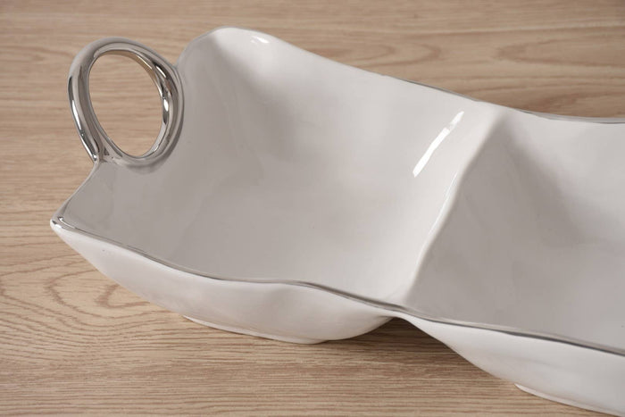 White ceramic serving dish with a handle on a wooden surface