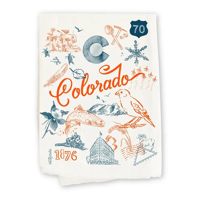 An off-white cotton tea towel featuring a colorful Colorado-themed graphic print with orange and slate blue illustrations, including the word 'Colorado', a mountain, a bird, and '1876'.