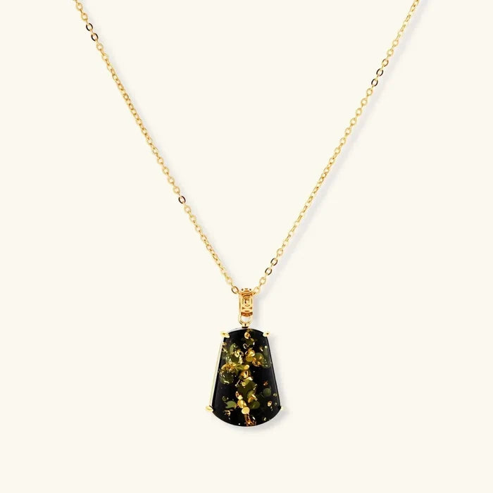 Forest Gold Green Amber Pendant Necklace with a trapezoid-shaped dark green stone flecked with gold, in a gold-tone prong setting.