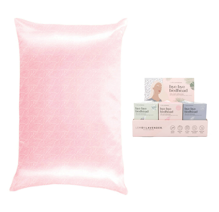 Pink pillowcase with packaging of 'bye bye bedhead' products on a white background