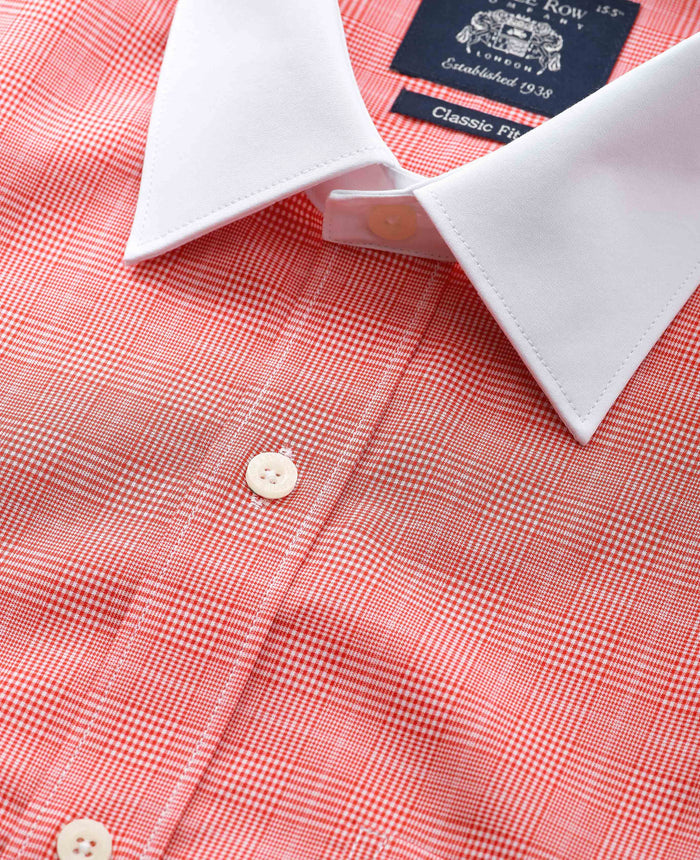 Close-up of a red checkered shirt with white collar and cuff, featuring a windsor collar