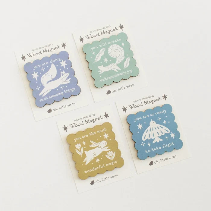 Set of four decorative wood magnets with illustrations and text on a white background